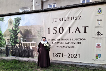 46. Siostra Maria Pia przed klasztorem przy banerach jubileuszowych, Przasnysz, 07.08.2021, fot. E. Łukasiak